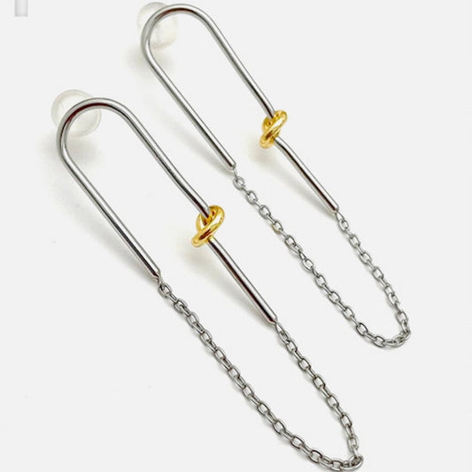 Pendientes de plata con botón dorado.